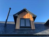 gable windows of a converted traditional rural scottish property showcasing timber cladding and aluminium juliet windows