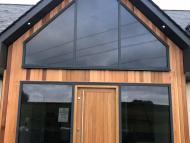 front entrance to a converted traditional rural scottish property showcasing solid timber door and aluminium glazed gable