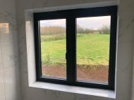 internal view from a gable windows of a converted traditional rural scottish property showcasing an aluminium juliet window - both windows closed