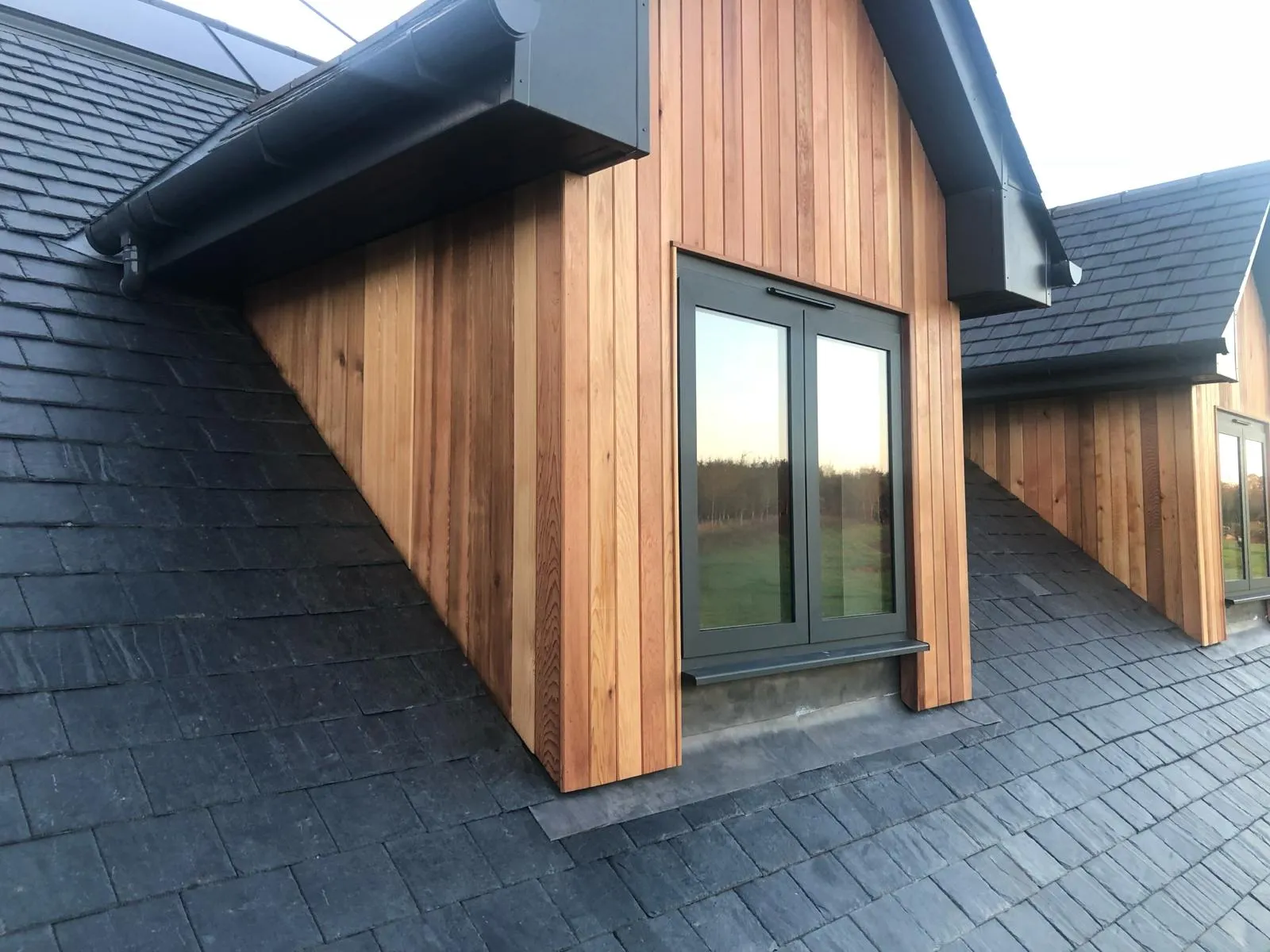 gable windows of a converted traditional rural scottish property showcasing timber cladding and aluminium juliet windows