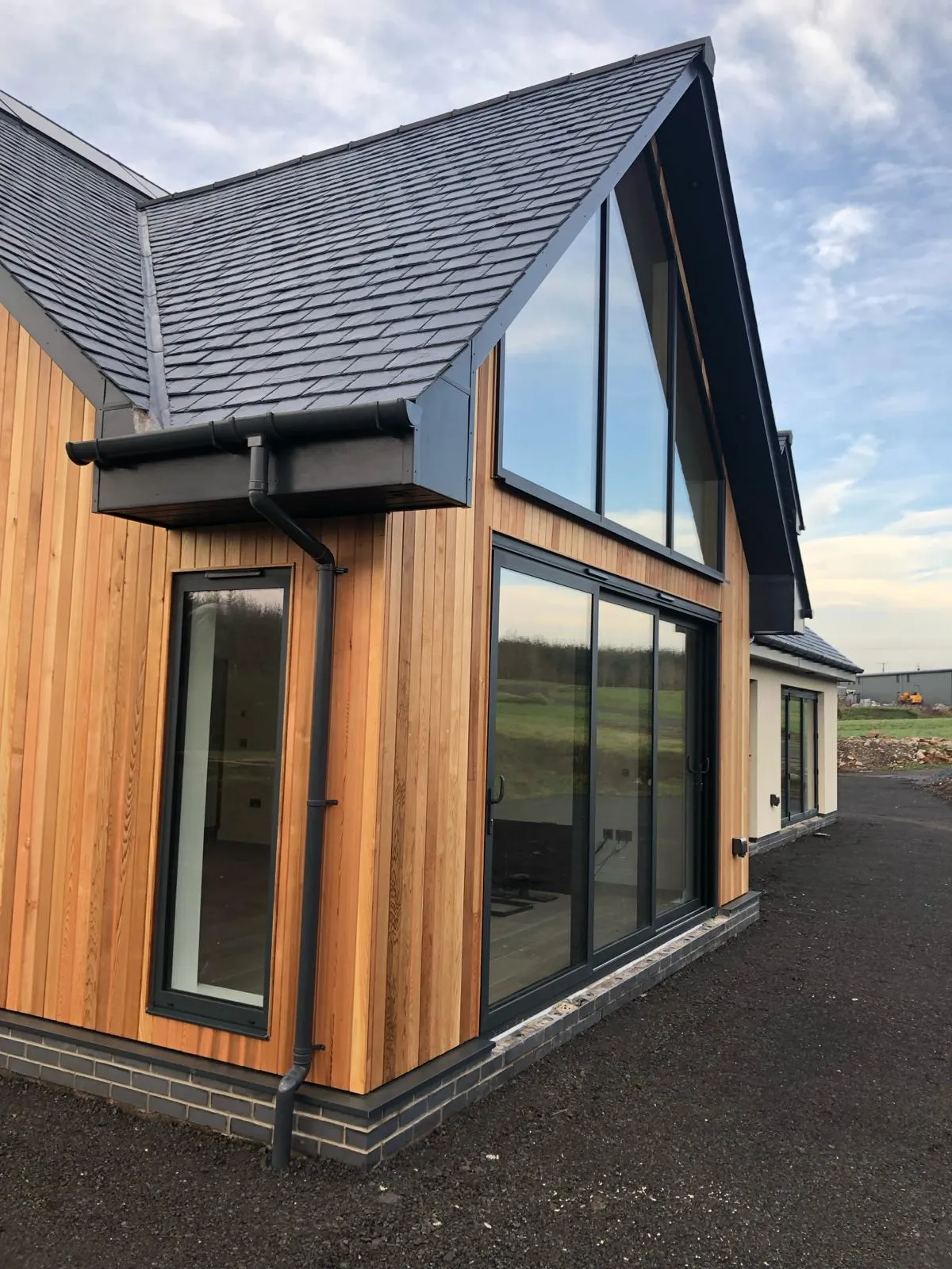 front entrance to a converted traditional rural scottish property showcasing solid timber door and aluminium glazed gable