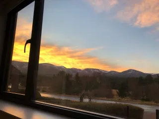 Sunset over Coire an t-Sneachda in the Cairngorms, Scotland viewed over through aluminium framed window 