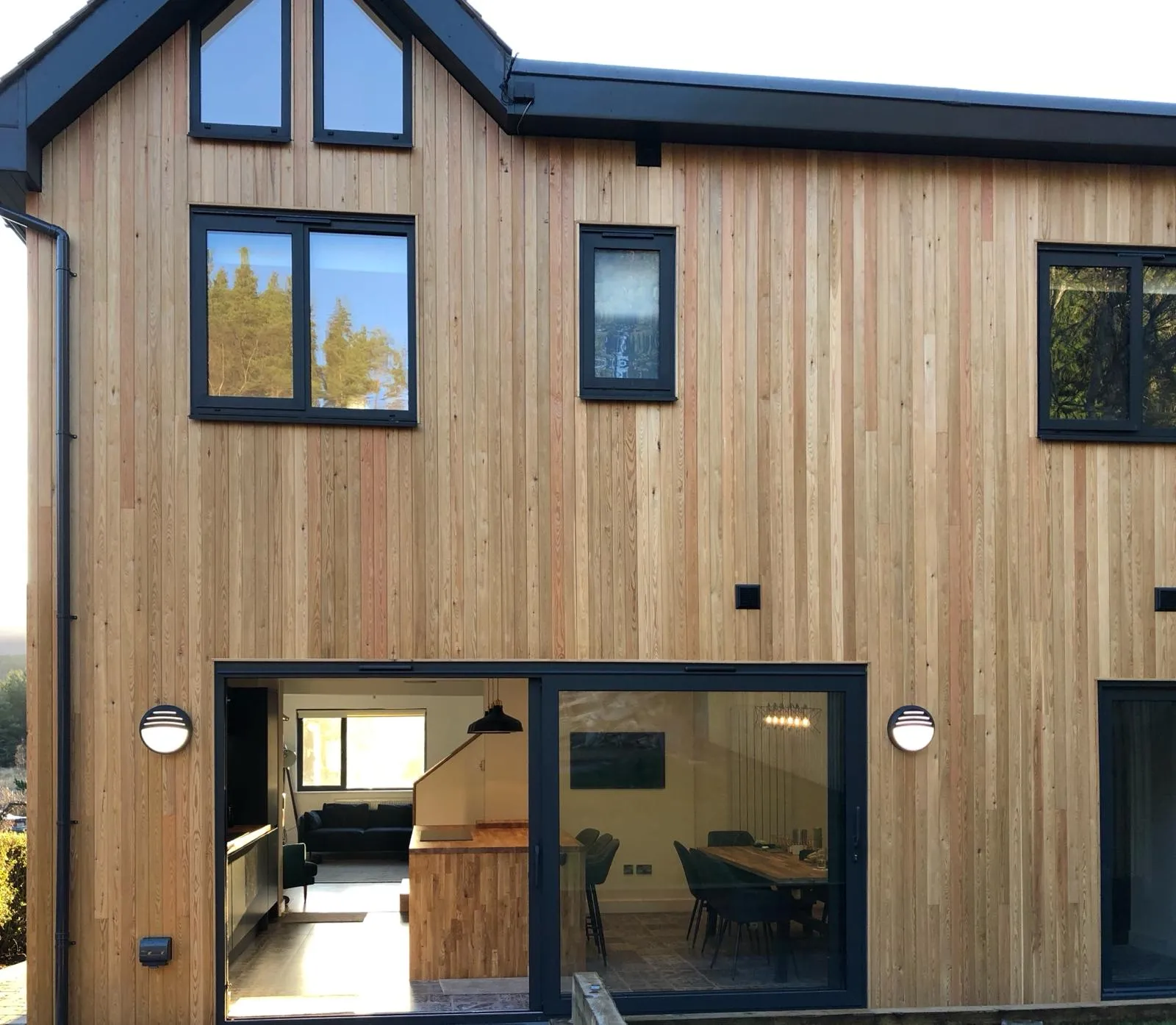 House clad in Scotch larch showing aluminium sliding doors and windows