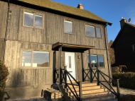 newly converted forestry house in the cairngorms scotland clad in scotch larch with steps and handrails leading to front door