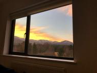 sunset over Coire an t-Sneachda in the Cairngorms, Scotland viewed over through aluminium framed window 